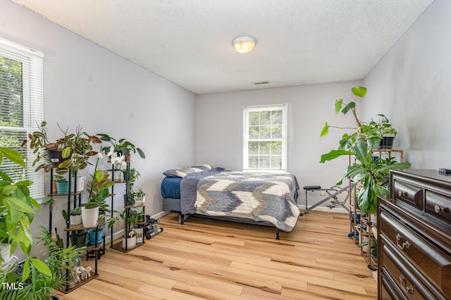 bedroom featuring wood finished floors and a textured ceiling