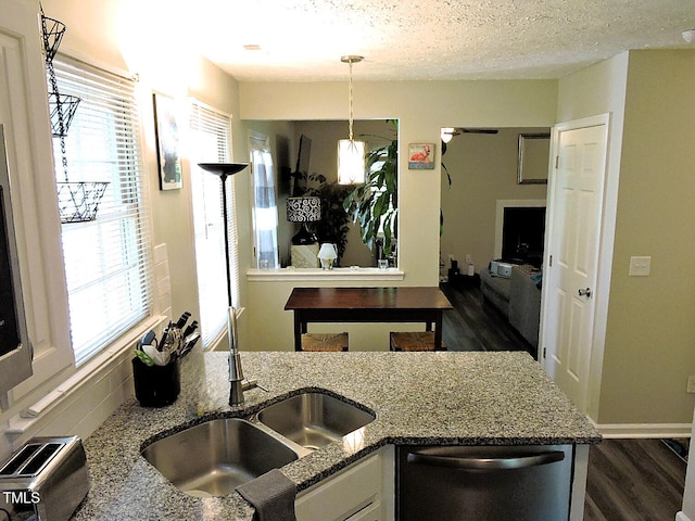 8 Woodsprite Ct, Durham, NC 27703 - kitchen featuring stainless steel dishwasher, a sink, dark wood finished floors, dark stone countertops, and a textured ceiling
