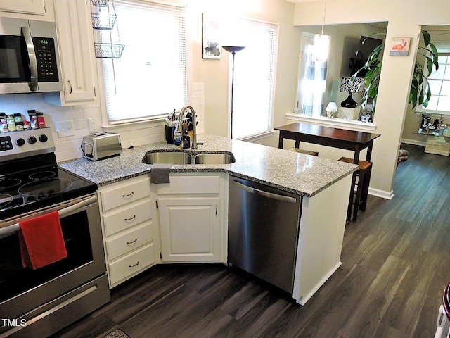 8 Woodsprite Ct, Durham, NC 27703 - kitchen featuring appliances with stainless steel finishes, a sink, dark wood finished floors, white cabinetry, and light stone counters
