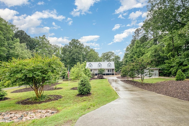 view of front of house featuring a front lawn, driveway, and covered porch
