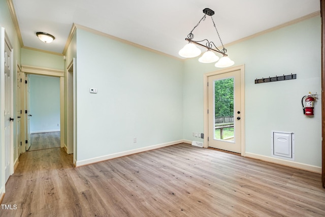 unfurnished dining area featuring crown molding, light wood finished floors, and baseboards