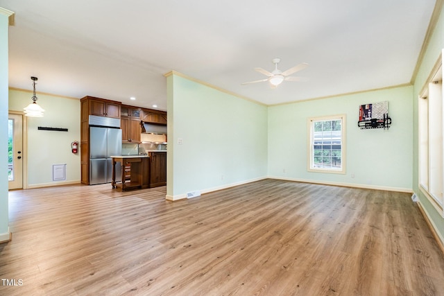unfurnished living room featuring a ceiling fan, light wood-style floors, crown molding, baseboards, and recessed lighting