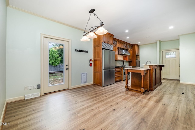 kitchen featuring stainless steel appliances, under cabinet range hood, crown molding, baseboards, and brown cabinetry