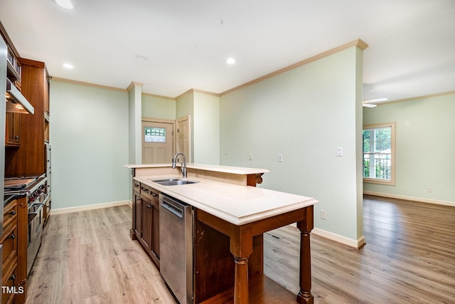 kitchen featuring a sink, appliances with stainless steel finishes, ornamental molding, light wood-style flooring, and a kitchen island with sink