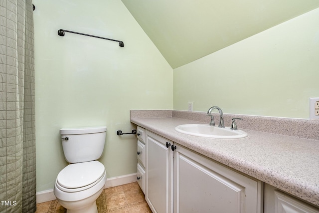bathroom with toilet, vanity, vaulted ceiling, tile patterned flooring, and baseboards