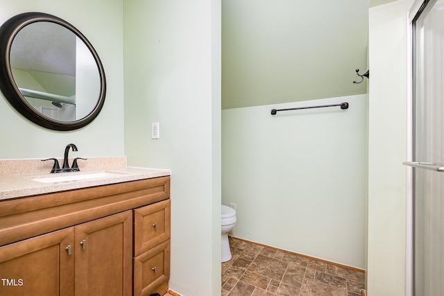bathroom with toilet, vanity, and stone finish floors