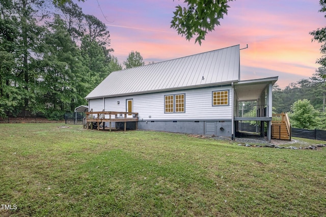 rear view of house with stairway, a deck, metal roof, and a yard