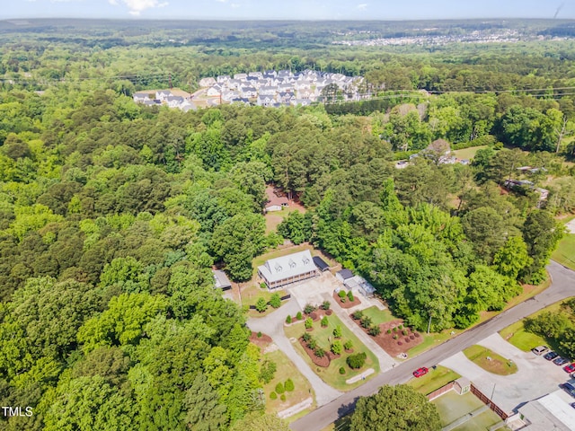 aerial view of property and surrounding area featuring a forest