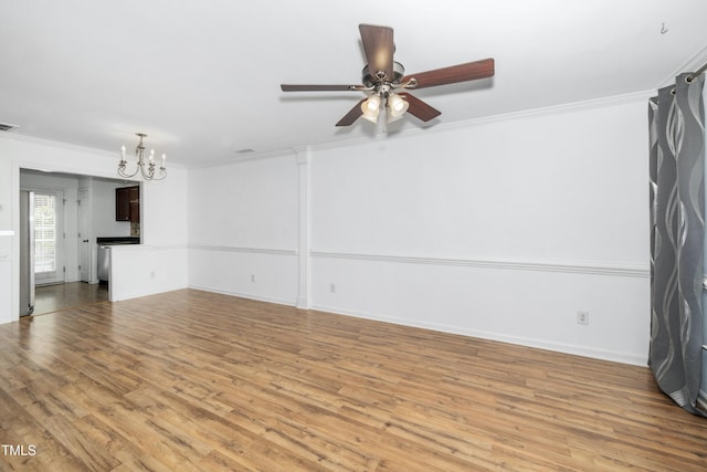 unfurnished living room with a chandelier, ornamental molding, light wood-type flooring, ceiling fan, and baseboards