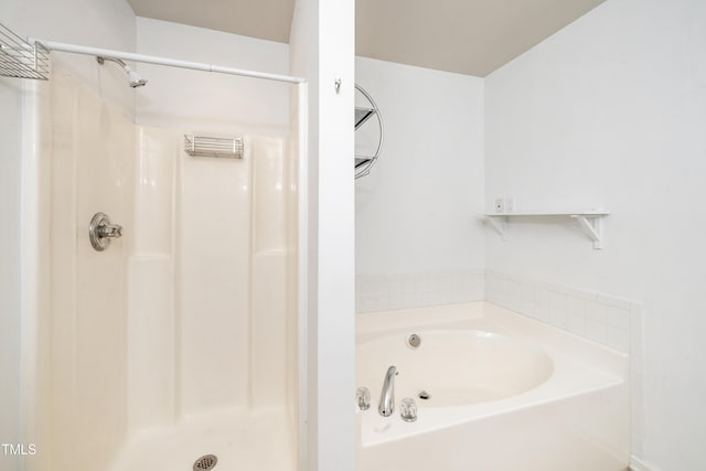 full bathroom featuring a shower stall and a bath