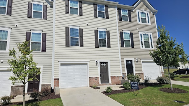 904 Romeria Dr, Durham, NC 27713 - townhome / multi-family property with brick siding, driveway, a garage, and a front yard