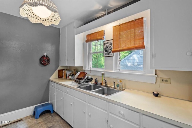 1314 Glendale Ave, Durham, NC 27701 - kitchen with a sink, light countertops, white cabinets, and tile patterned flooring