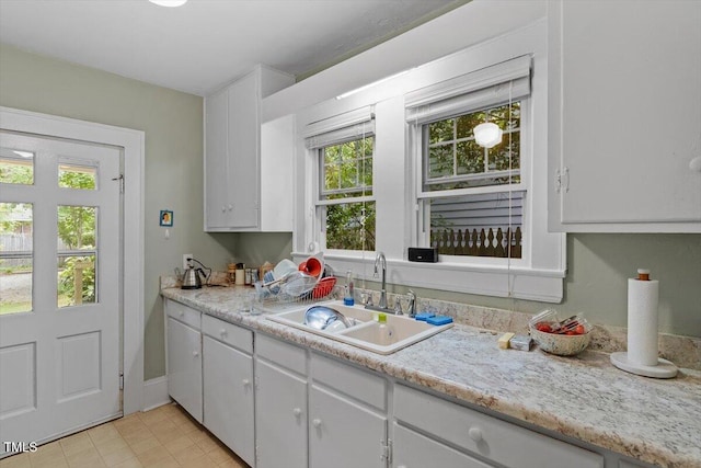 1314 Glendale Ave, Durham, NC 27701 - kitchen with a sink, light countertops, white cabinets, and light tile patterned floors