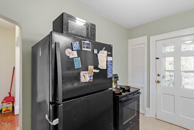 1314 Glendale Ave, Durham, NC 27701 - kitchen featuring black appliances, baseboards, arched walkways, and light tile patterned floors