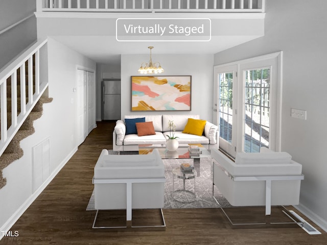 living area featuring baseboards, wood finished floors, a chandelier, and stairway