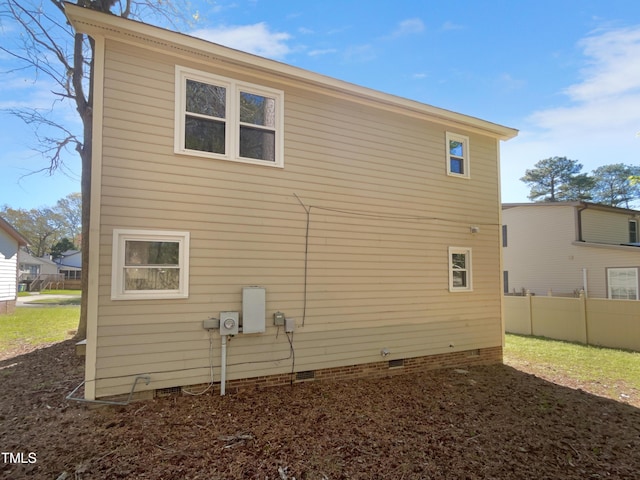 rear view of house featuring crawl space and fence
