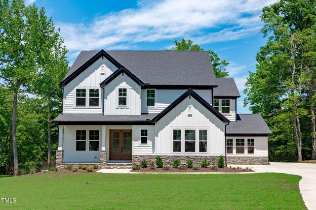 248 Ashford Dr, Pittsboro, NC 27312 - modern inspired farmhouse with board and batten siding, stone siding, french doors, a front yard, and roof with shingles