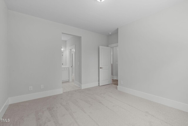 248 Ashford Dr, Pittsboro, NC 27312 - unfurnished bedroom with light colored carpet, baseboards, and ensuite bath