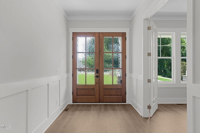 248 Ashford Dr, Pittsboro, NC 27312 - doorway featuring french doors, light wood-style floors, plenty of natural light, a decorative wall, and a wainscoted wall