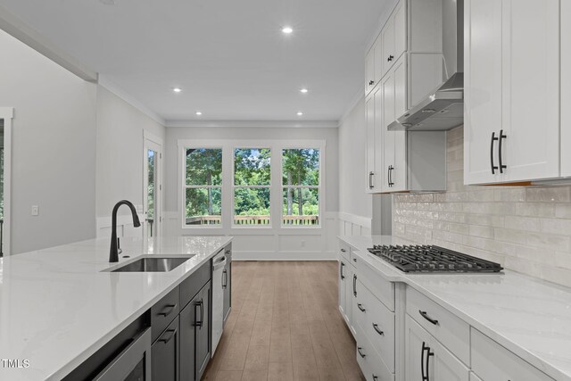 248 Ashford Dr, Pittsboro, NC 27312 - kitchen with a sink, stainless steel appliances, white cabinets, light wood-style flooring, and wall chimney range hood