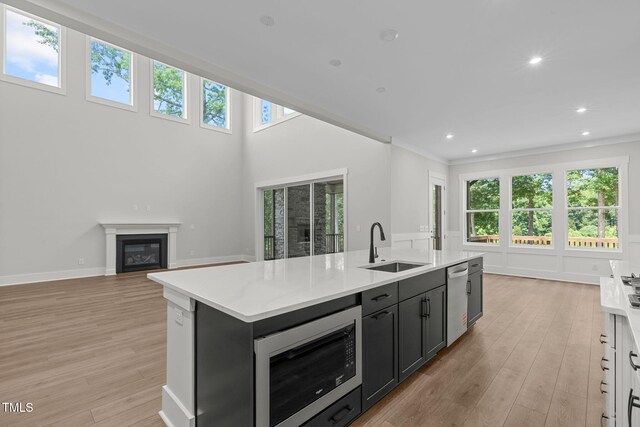 248 Ashford Dr, Pittsboro, NC 27312 - kitchen featuring a sink, dishwasher, built in microwave, light countertops, and a center island with sink