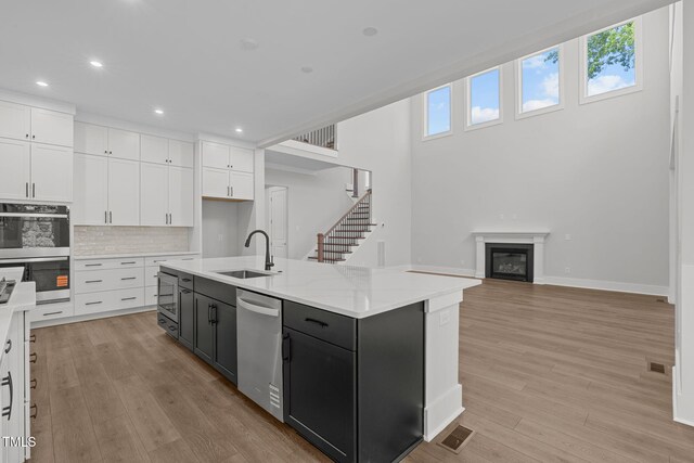 248 Ashford Dr, Pittsboro, NC 27312 - kitchen featuring a sink, appliances with stainless steel finishes, white cabinetry, recessed lighting, and light wood-style flooring