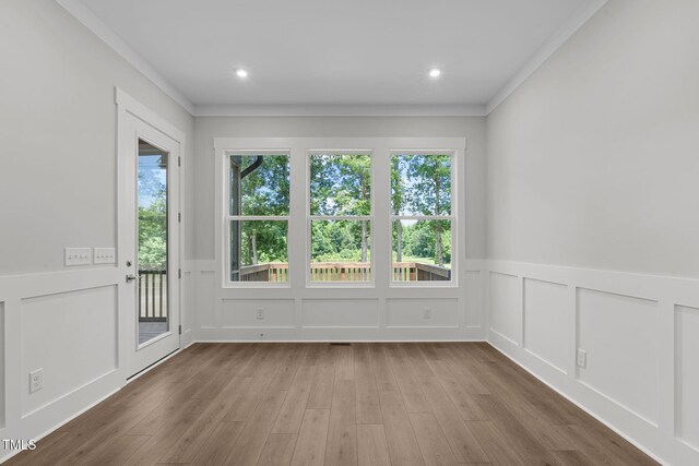 248 Ashford Dr, Pittsboro, NC 27312 - empty room featuring a decorative wall, wood finished floors, plenty of natural light, wainscoting, and recessed lighting