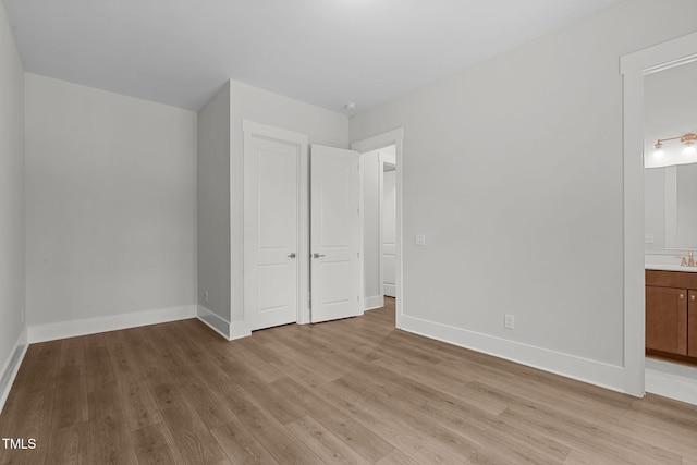 248 Ashford Dr, Pittsboro, NC 27312 - unfurnished bedroom with light wood finished floors, baseboards, and ensuite bathroom