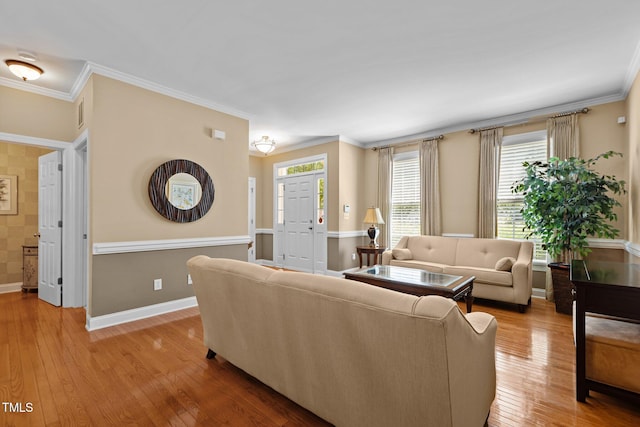 living room featuring crown molding, wood-type flooring, and baseboards