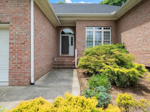 11221 Paddy Hollow Ln, Raleigh, NC 27614 - doorway to property featuring roof with shingles, brick siding, and a garage