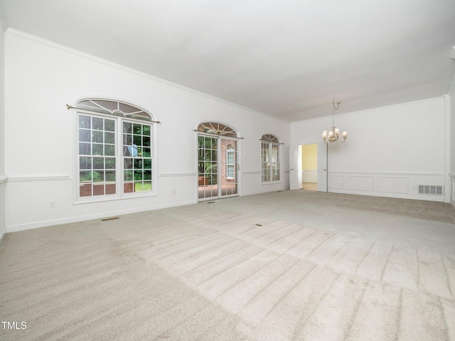 11221 Paddy Hollow Ln, Raleigh, NC 27614 - unfurnished living room with a chandelier, plenty of natural light, ornamental molding, carpet flooring, and wainscoting