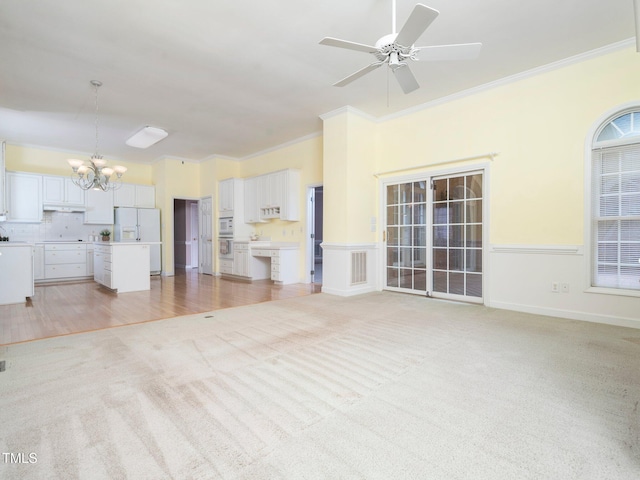 11221 Paddy Hollow Ln, Raleigh, NC 27614 - unfurnished living room featuring a chandelier, light colored carpet, ornamental molding, and a ceiling fan