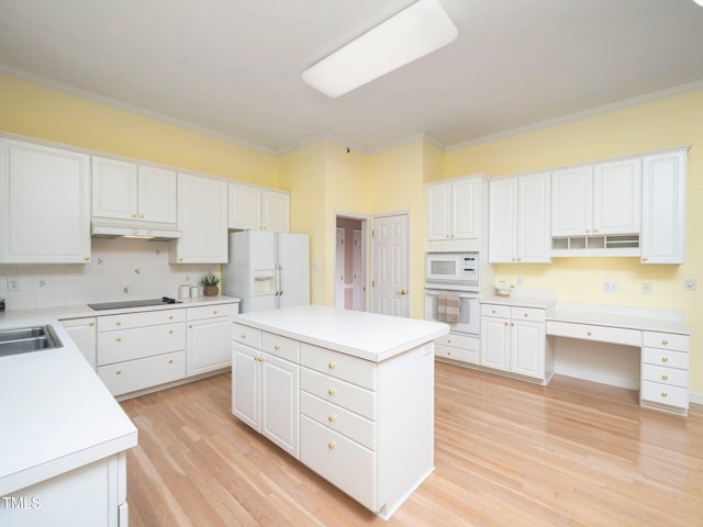 11221 Paddy Hollow Ln, Raleigh, NC 27614 - kitchen with white appliances, under cabinet range hood, crown molding, white cabinets, and light wood-type flooring