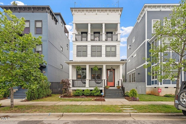 italianate home with covered porch, a balcony, and fence