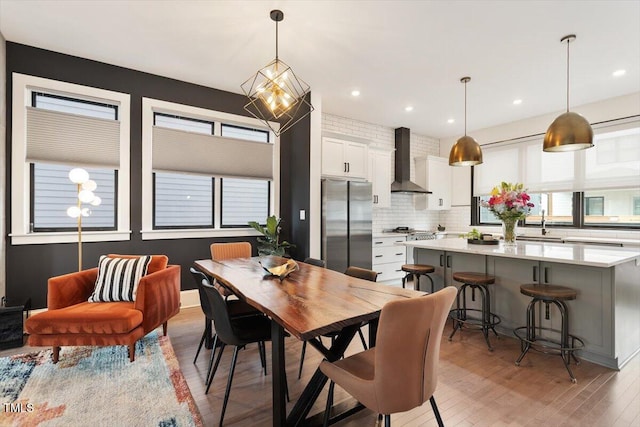 dining space with light wood-style flooring, plenty of natural light, and recessed lighting