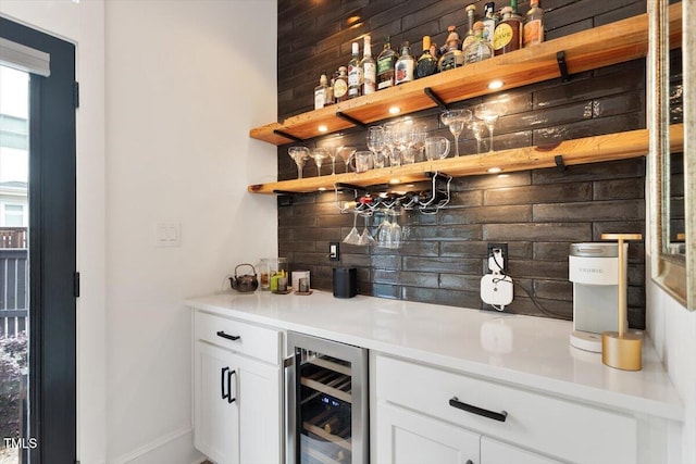 indoor dry bar with beverage cooler, decorative backsplash, and baseboards