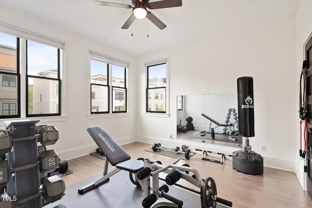 workout room with a ceiling fan, wood finished floors, and baseboards
