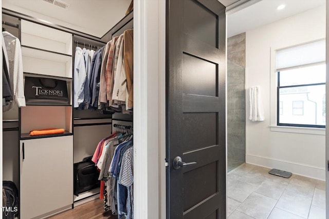 walk in closet with light tile patterned floors