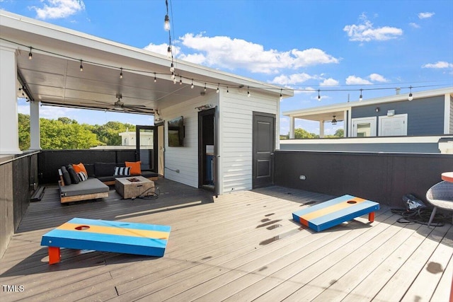 wooden terrace with an outdoor living space with a fire pit and a ceiling fan