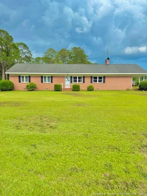 209 S Main St, Salemburg, NC 28385 - ranch-style home with a front yard, a chimney, and brick siding