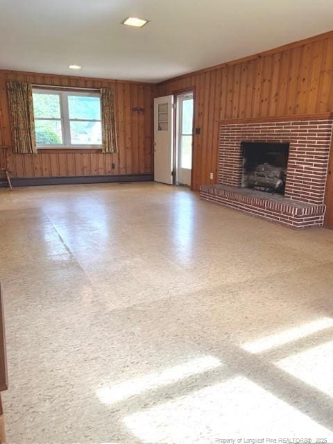 209 S Main St, Salemburg, NC 28385 - unfurnished living room with wood walls, plenty of natural light, and a brick fireplace