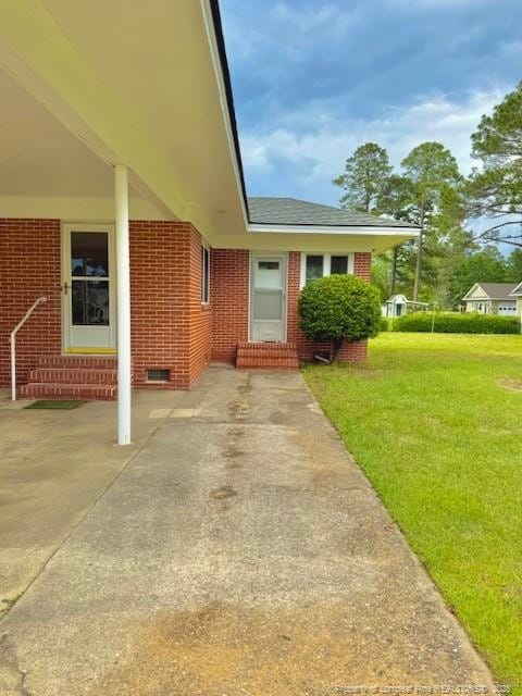 209 S Main St, Salemburg, NC 28385 - doorway to property with brick siding and a lawn