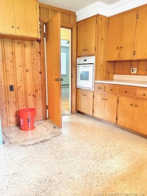 209 S Main St, Salemburg, NC 28385 - kitchen featuring oven, light countertops, ornamental molding, and wood walls