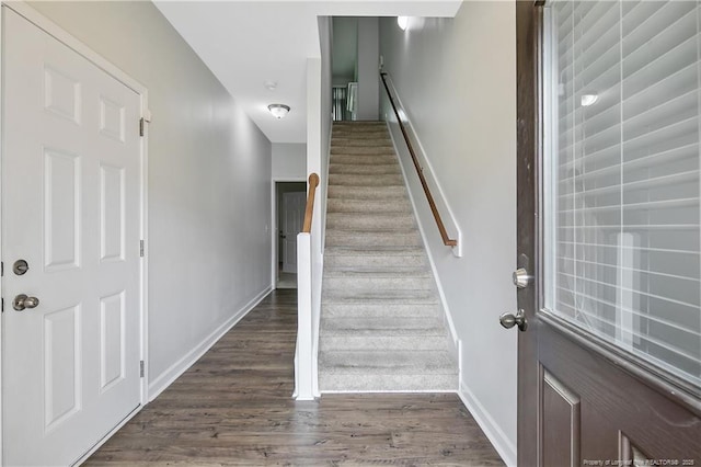 staircase with wood finished floors and baseboards