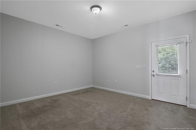 spare room featuring carpet floors and baseboards