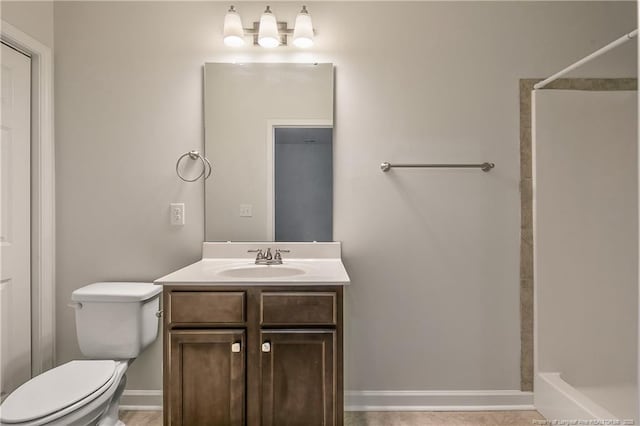 bathroom featuring a shower, toilet, and vanity