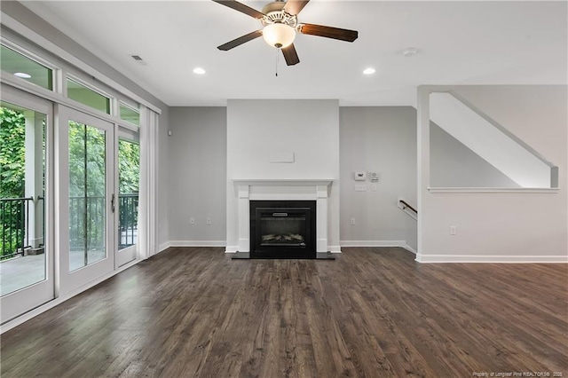 unfurnished living room with dark wood-type flooring, ceiling fan, baseboards, a glass covered fireplace, and recessed lighting