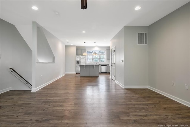 unfurnished living room featuring dark wood finished floors, baseboards, and recessed lighting