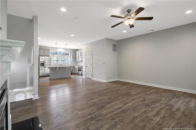 unfurnished living room with ceiling fan, dark wood-type flooring, recessed lighting, a fireplace, and baseboards