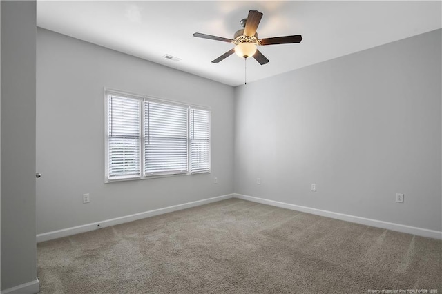 carpeted empty room featuring ceiling fan and baseboards